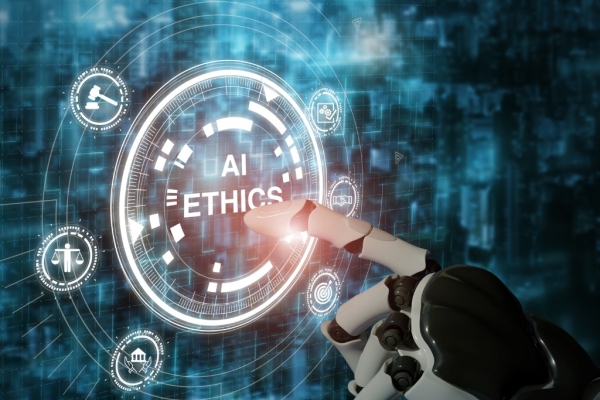 Computer generated image of a humanoid robot hand pointing to the words AI ethics on a screen. There are various icons surrounding the words including a figure holding the scales of justice, a tick, a bullseye, building and gavel.